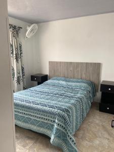 a bedroom with a bed with a blue comforter at Apartamento Fontana in Bucaramanga