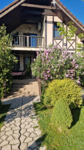 een huis met een loopbrug ervoor met bloemen bij Guest House on Lesnaya in Leski