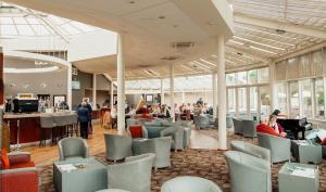 a lobby with people sitting in chairs in a building at Alona Hotel in Motherwell