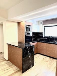 a kitchen with black counter tops and a microwave at Amaryllis in Platanias