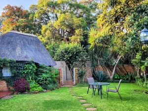 a garden with a table and chairs and a building at Tree Aloe Guest House in Mokopane
