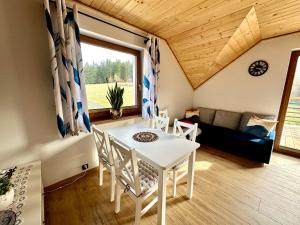 a room with a table and chairs and a couch at Domek SAMI SWOI in Zawoja
