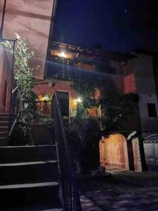 - un bâtiment avec des escaliers devant lui la nuit dans l'établissement Come a casa tua, à Castelletto sopra Ticino