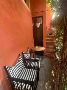 a patio with two benches and a table and a door at Come a casa in Castelletto sopra Ticino