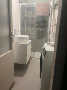 La salle de bains blanche est pourvue d'un lavabo et d'une douche. dans l'établissement Come a casa tua, à Castelletto sopra Ticino