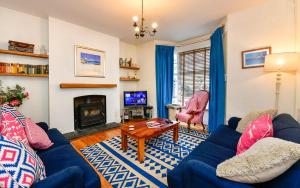 uma sala de estar com um sofá azul e uma lareira em Beautiful family home in Mumbles, with garden em The Mumbles