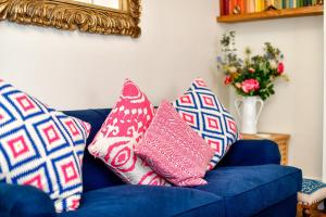 Sofá azul con almohadas y espejo en Beautiful family home in Mumbles, with garden en The Mumbles