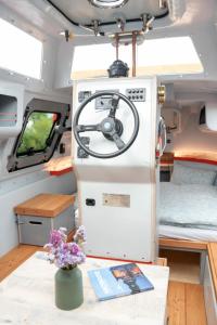 an interior view of an rv with a table and flowers at Ausgebautes Freifallrettungsboot KNUTSCHKUGEL in Hamburg