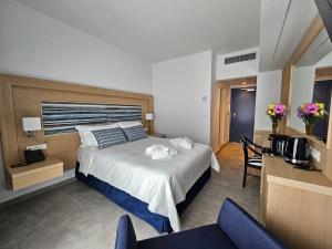 a bedroom with a bed and a table and chairs at O Paradise beach Resort and Spa in Magoúla