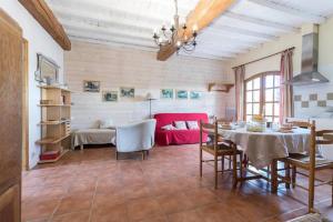 a living room with a table and a red couch at La Ferme Montplaisir in Montesquieu-Volvestre
