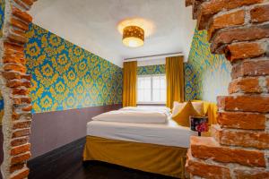 ein Schlafzimmer mit blauen und gelben Wänden und einem Bett in der Unterkunft Georgi Schloss - Boutique Hotel in Ehrenhausen