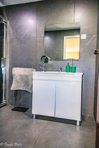 uma casa de banho com um lavatório branco e um espelho. em A qintinha O recanto do Sossego 2 em Paredes de Coura