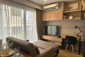 sala de estar con sofá y TV en Studio 1BR Pool Gym Wifi 5 mins from Sathorn, en Bangkok