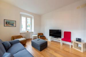 a living room with a couch and a tv at ALTIDO Family friendly Apt for 6, near Royal Palace Museum in Genoa