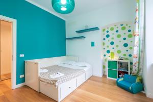 a small bedroom with a bed and a blue wall at ALTIDO Family friendly Apt for 6, near Royal Palace Museum in Genoa