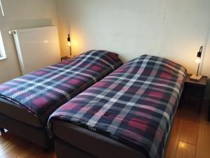 een bed in een kamer met twee lampen op twee tafels bij Cosy Corner in Lommel