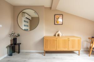 a room with a wooden dresser and a mirror at St Florian Apartments in Kraków