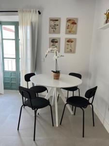 uma mesa branca e cadeiras com uma planta sobre ela em The sunnydise Apartment LUXURY DUPLEX in the city center em Málaga
