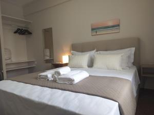 um quarto com uma grande cama branca com toalhas em Nefeli -1BR Lux Apartment - Tsimiski Ladadika - Explore Center by foot - Close to Aristotelous square em Tessalônica