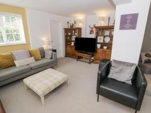 sala de estar con sofá y silla en Jubilee Cottage en Stratford-upon-Avon