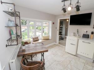 cocina con mesa de madera y encimera en Jubilee Cottage en Stratford-upon-Avon