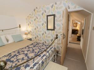 1 dormitorio con 1 cama con colcha azul y blanca en Jubilee Cottage en Stratford-upon-Avon