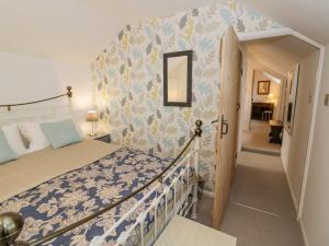 une chambre avec un lit avec un couvre-lit bleu et blanc dans l'établissement Jubilee Cottage, à Stratford-upon-Avon