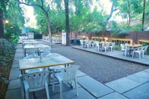 a row of tables and white chairs at a restaurant at Hotel Dhruva-Solapur Pet friendly in Solapur