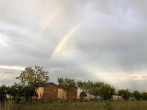 a rainbow in the sky over a field at Arkhilo's cottage in Dedoplis Tskaro