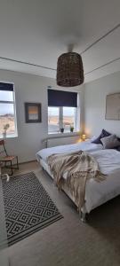 a bedroom with a large bed and a chandelier at The Old School House - Gaulverjaskoli in Selfoss