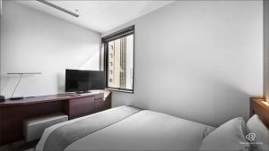 a hotel room with a bed and a window at Daiwa Roynet Hotel Shimbashi in Tokyo