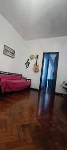 a room with a bed and a guitar on the wall at Mini quarto in Rio de Janeiro