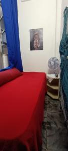 a bedroom with a bed with red and blue sheets at Mini quarto in Rio de Janeiro