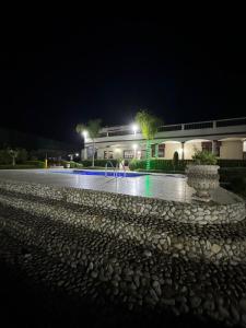 a building at night with a fountain in front of it at Gîte Jnane fès in El Jadida