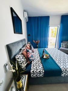 1 dormitorio con 1 cama grande y cortinas azules en Urszula's apartment - apartments by the sea, en Agios Andreas - Mesenia