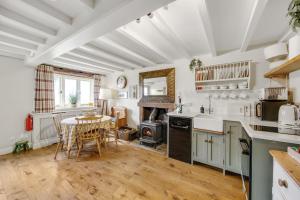 uma cozinha com uma mesa e um fogão forno superior em Lakeview cottage - Upper Hulme em Leek