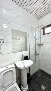 a white bathroom with a sink and a shower at Meshia Apartment in Kazbegi +30 photos