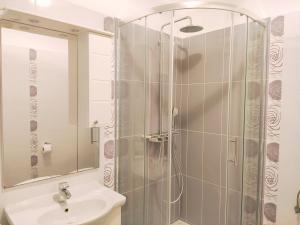 La salle de bains est pourvue d'une douche et d'un lavabo. dans l'établissement Siesta Apartments, à Šibenik