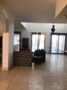 samara villas luxury في شرم الشيخ: غرفة معيشة فارغة مع أريكة ونوافذ