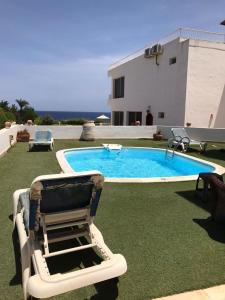 a chair and a swimming pool in a yard at samara villas luxury in Sharm El Sheikh