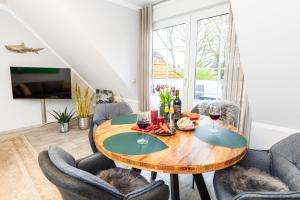 a dining room with a table with two glasses of wine at Birkenstraße 6 Haus II Whg6 in Zingst