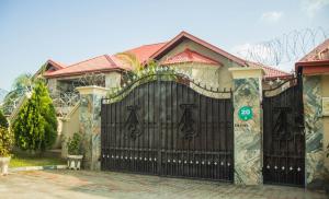 una puerta negra delante de una casa en J's Place Hotel, en Abuja