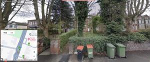 un grupo de cubos de basura sentados junto a una valla en Spacious one bedroom flat w/ parking, en Walsall