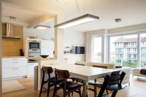 a kitchen and dining room with a table and chairs at Boutique appartment with vue on sea and dunes in Koksijde