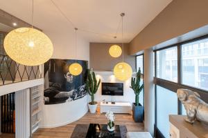 uma sala de estar com duas luzes pendentes e uma televisão em Beau Loft Lorient - centre ville em Lorient
