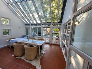 a conservatory with a table and chairs and a glass ceiling at lichtdurchflutetes Architektenhaus in Balingen