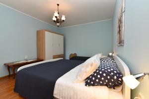 a bedroom with a bed with a black blanket and pillows at Apartments Nevina 1230 in Pula