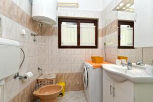 a small bathroom with a sink and a toilet at Apartments Nevina 1230 in Pula