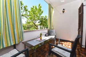 einen Balkon mit einem Tisch und Stühlen sowie einem Fenster in der Unterkunft Apartments Nevina 1230 in Pula