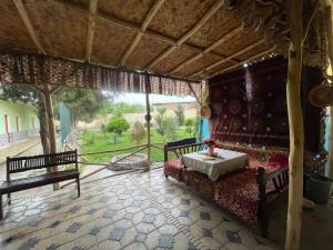 une chambre avec un canapé, une table et des bancs dans l'établissement Sohil boyi, à Ferghana